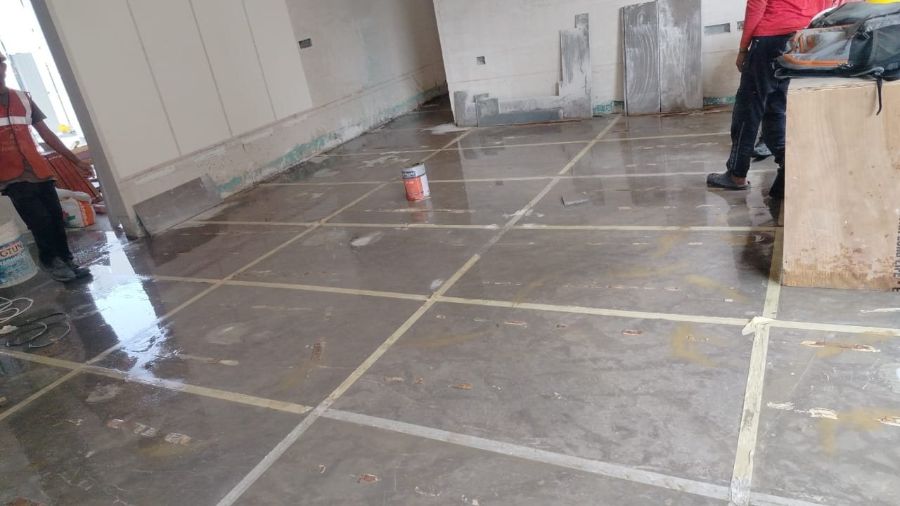 Large-format floor tiles laid in a living area with joints taped