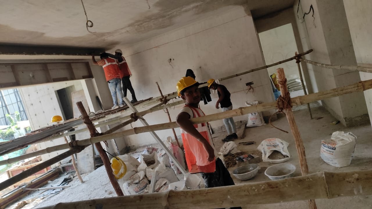 Plastering crew working from scaffolding inside an apartment